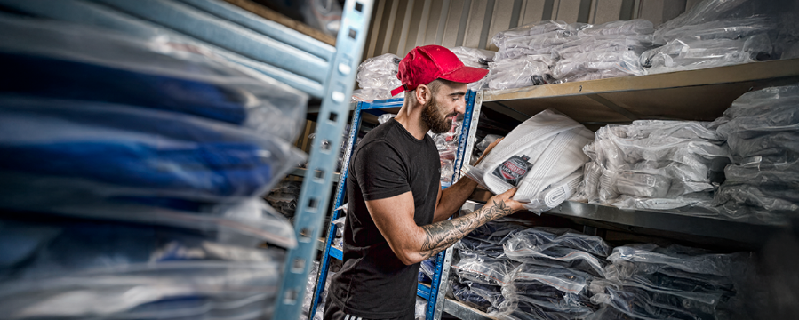 guy packing vacuum packed karate uniforms into a self storage unit