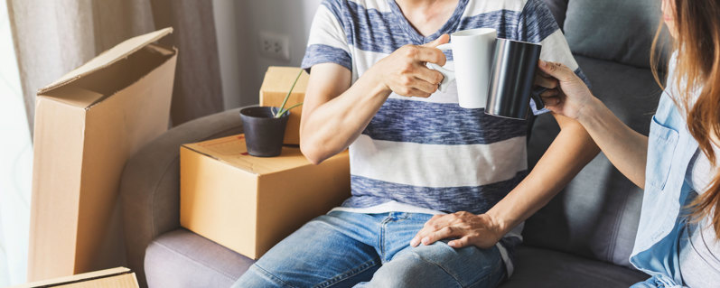 Person or couple sitting drinking tea with storage boxes in the background