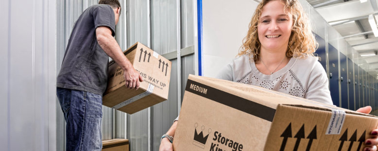 A couple packing boxes into their storage unit