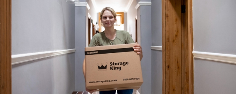 A Storage King customer, using a branded Storage King moving box to transport items to their storage unit.