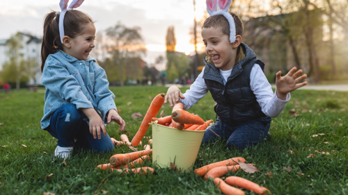 Children with bunny ears and a bucket of carrots