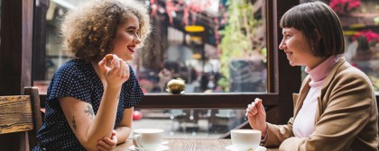 Two Women Sitting At A Table Drinking Coffee At Cafe Sobar