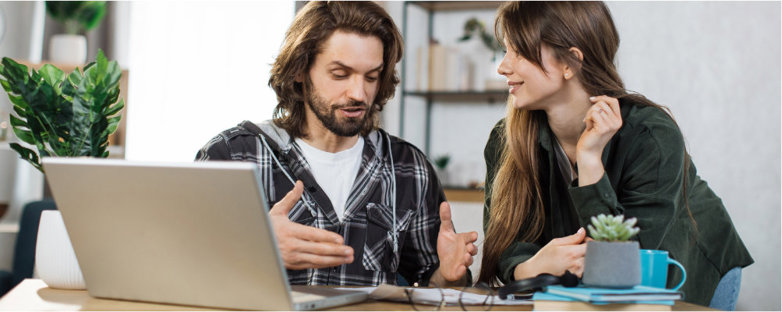 A couple discussing self storage options in Banbury in front of a laptop