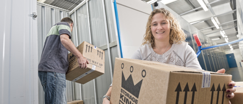 Couple Moving Boxes into Storage Unit