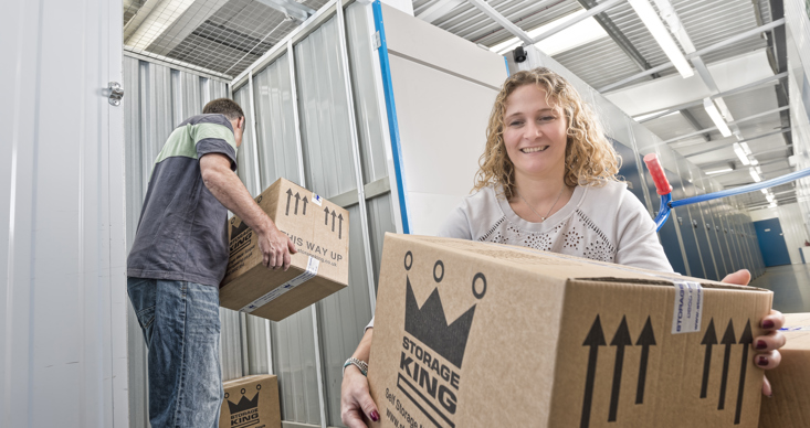 Couple Moving Boxes into Storage Unit