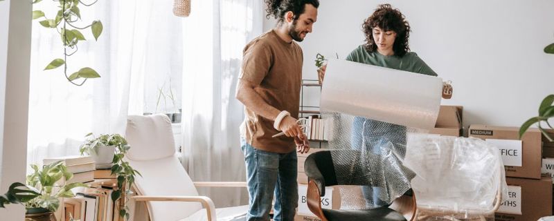 Couple bubble wrapping moving items