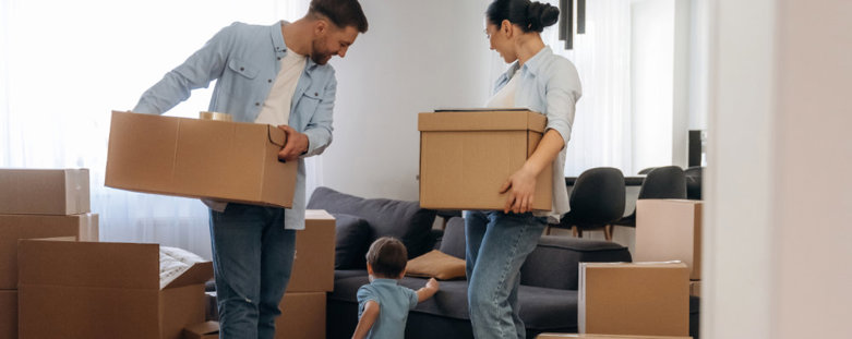 A couple and their child packing up a room into moving boxes